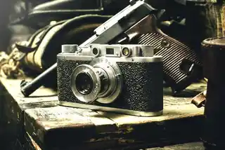 Don't pay the ransom Vintage camera on an old wooden surface with a soft-focus background of antique items, invoking a sense of nostalgia and the timeless nature of photography.