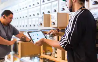 Action Plan: Accurately Inventory Your IT Two people managing inventory using a digital tablet in a modern storage facility, demonstrating efficient inventory control and digital management practices.