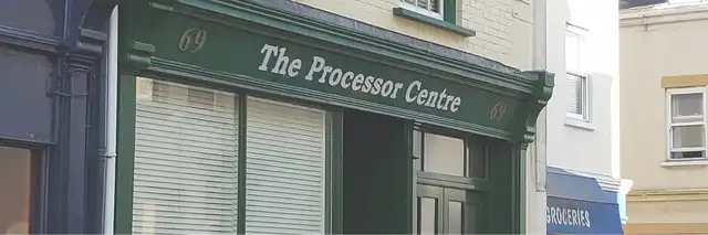 Exterior of 'The Processor Centre' building with a classic storefront, showcasing the establishment's name and number 69 on a green overhang.
